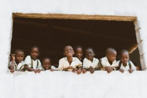 children standing in front of window